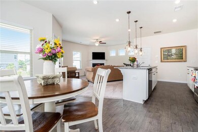 Dining area with a ceiling fan, dark wood-type flooring, a fireplace, baseboards, and recessed lighting