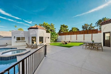 Fenced backyard with outdoor dining area, a patio area, and a pool with connected hot tub