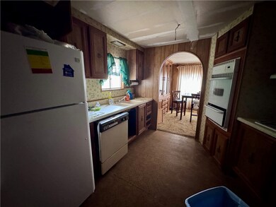 Kitchen featuring white appliances, arched walkway