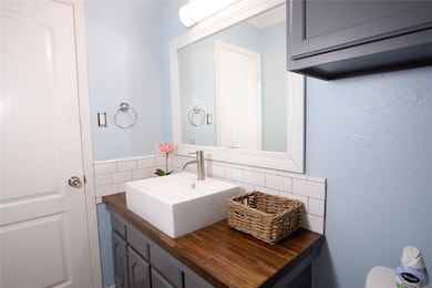 Bathroom featuring vanity and backsplash