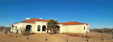 Back of house with a tile roof and stucco siding