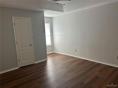 Unfurnished room featuring dark wood-style flooring and baseboards