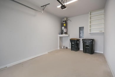 Garage with electric water heater, baseboards, a 