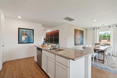 Kitchen with light stone counters, dishwasher, vis