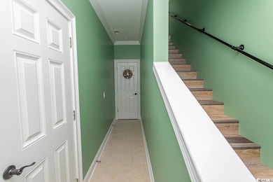 Stairs featuring tile patterned flooring, baseboards, and crown molding