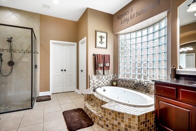 The Primary en suite Bathroom offers it all with tons of space! 2 vanities, garden bathtub, glass tile shower, large wardrobe closet.