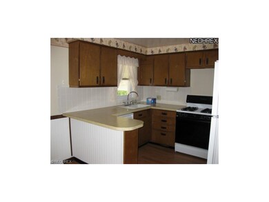 The kitchen has new laminate wood floors, applianc