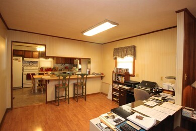 A view from the dining area into the kitchen. Owner is currently using it as an office 