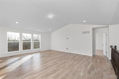 Unfurnished living room with lofted ceiling, light wood finished floors, and recessed lighting