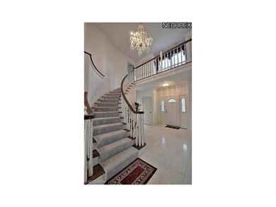 An elegeant two-story foyer with tile flooring. Le