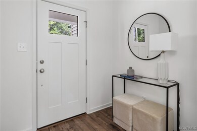Entrance foyer with dark hardwood flooring and ple