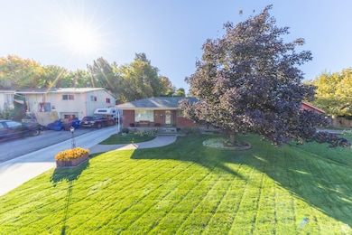 View of front of home with a front lawn, concrete driveway, and brick siding