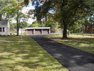 VIEW OF DRIVEWAY TO LARGE 3 PLUS GARAGE AND PARKING AREA