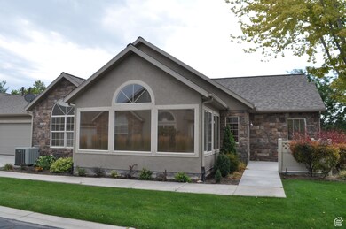 View of front of home featuring stone siding, a front yard, stucco siding, and an attached garage