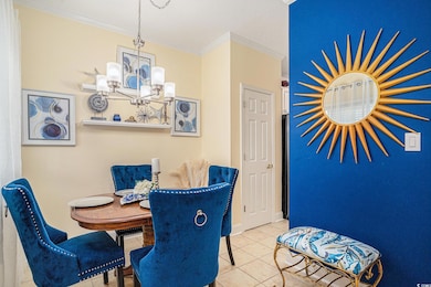 Dining space featuring a chandelier, crown molding, and tile patterned floors