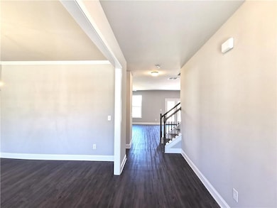 Hall featuring dark wood-type flooring, stairs, and ornamental molding