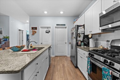 Kitchen with appliances with stainless steel finishes, a sink, white cabinetry, tasteful backsplash, and recessed lighting