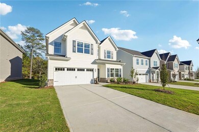 View of front facade with a garage, concrete driveway, a residential view, and a front lawn