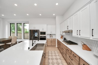 This modern kitchen features sleek white cabinets,