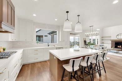 Kitchen with a breakfast bar, backsplash, light wood-type flooring, plenty of natural light, and recessed lighting