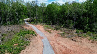 The gravel driveway leads to the first hilltop whi
