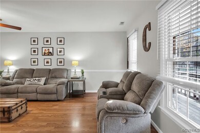 Living room with ceiling fan and light wood-type f
