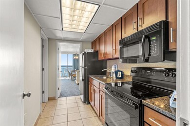 Kitchen featuring dark stone countertops, brown ca