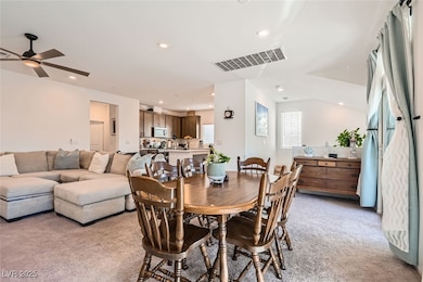 Dining room with light carpet, visible vents, and