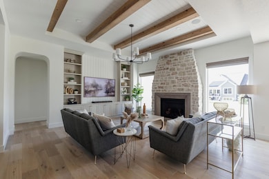 Stepped box vault ceiling, wood beams, tapered larger fireplace with concrete surround, custom entertainment built in with beadboard accents, upgraded full windows!