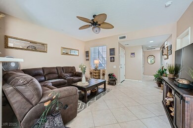 Living room featuring ceiling fan and light tile p