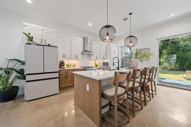Kitchen featuring concrete floors, white cabinetr
