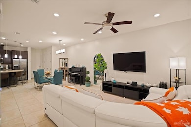 Living room with recessed lighting, light tile patterned floors, and ceiling fan