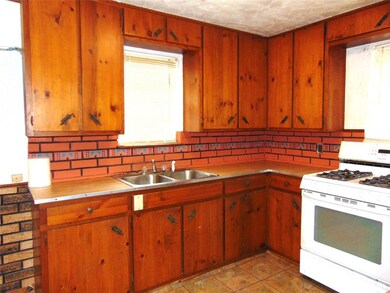 Kitchen with white range with gas cooktop, sink, d