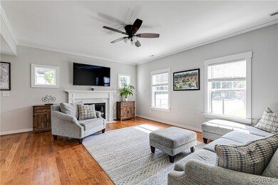 Living room with crown molding, wood floors, a cei