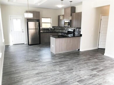 Kitchen with decorative backsplash, appliances with stainless steel finishes, a wealth of natural light, and pendant lighting