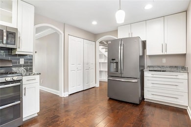 Kitchen with dark wood-style floors, stainless ste