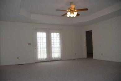 The large Living Room offers newer carpeting, a trey ceiling, & access to the back patio.