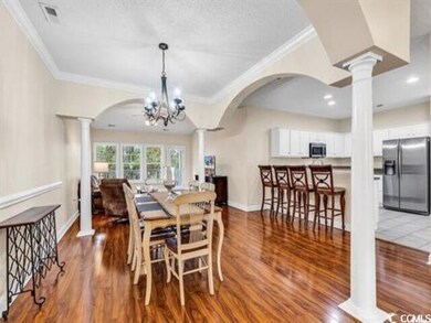 Dining space featuring decorative columns, an invi