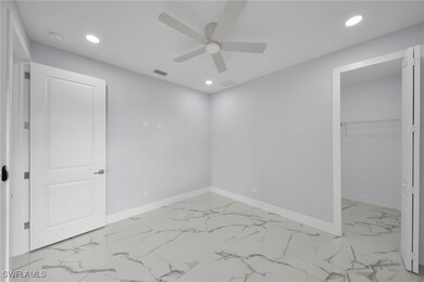 Unfurnished bedroom with marble look tiles, recess