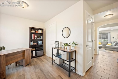 Home office featuring arched walkways, wood finish