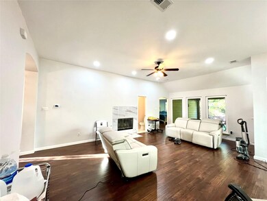 Living room with a premium fireplace, dark hardwood / wood-style flooring, ceiling fan, and lofted ceiling