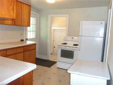 Kitchen looking from side enclosed porch towards 1