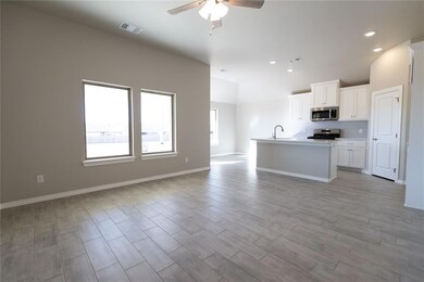 Kitchen featuring ceiling fan, appliances with sta