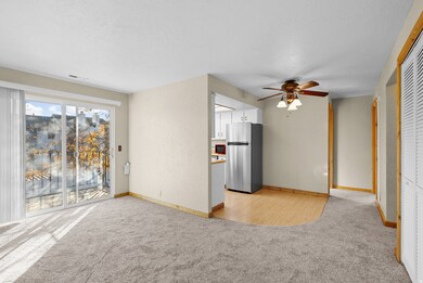 Unfurnished living room with light carpet and ceiling fan
