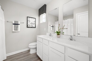 En-suite owner's bathroom features a tub/show combo, double bowl vanity, and luxury vinyl plank flooring.
