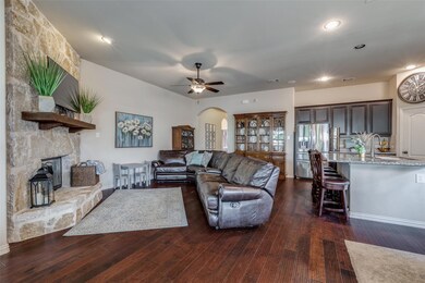 Living room with sink, a stone fireplace, dark woo