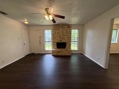 Unfurnished living room featuring a textured ceil