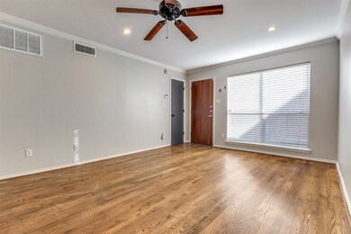 Spare room with crown molding, wood-type flooring, and ceiling fan