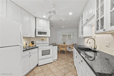 Kitchen featuring ceiling fan, sink, tasteful back