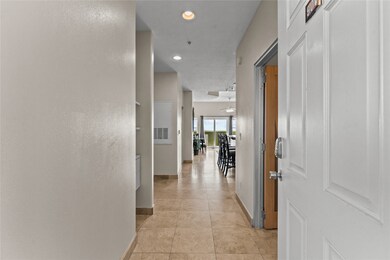 Entering the condo, featuring neutral walls and ti
